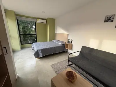 a living room with a bed and a couch at Deluxe Suite with Terrace in Barranquilla