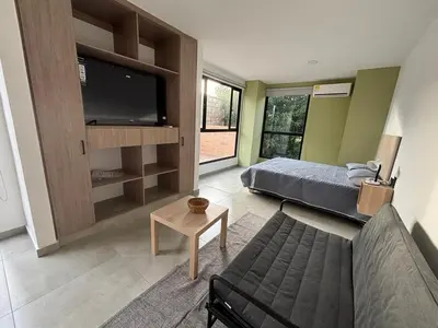 a living room with a couch and a flat screen tv at Deluxe Suite with Terrace in Barranquilla