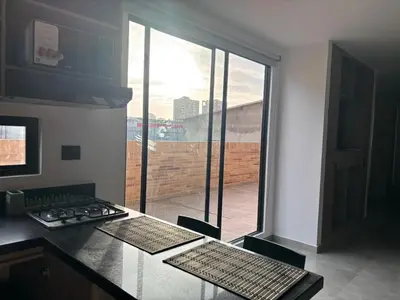 a kitchen with a counter top with a large window at Deluxe Suite with Terrace in Barranquilla