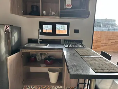 a small kitchen with a sink and a counter at Deluxe Suite with Terrace in Barranquilla