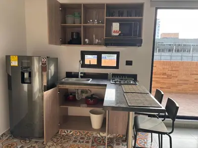 a small kitchen with a counter and a refrigerator at Deluxe Suite with Terrace in Barranquilla
