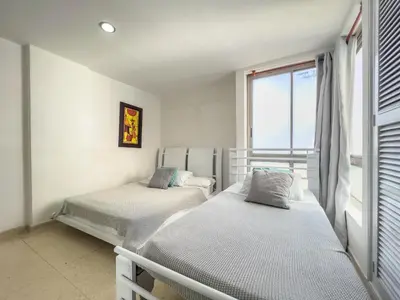 two beds in a room with a window at Caribbean Sunset - Apartamento con salida a la playa in Cartagena de Indias