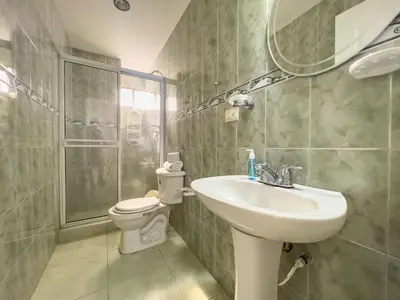 a bathroom with a sink and a toilet and a mirror at Caribbean Sunset - Apartamento con salida a la playa in Cartagena de Indias
