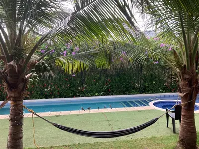 a hammock between two palm trees next to a swimming pool at Habitacion doble en Villakite ,Salinas del Rey in Juan de Acosta