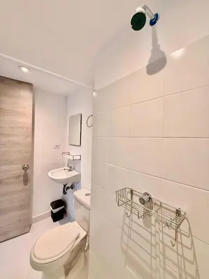 a white bathroom with a toilet and a sink at Modern Apartment with Ocean Views in Cartagena de Indias