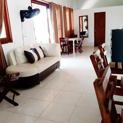 a living room with a white couch and chairs at La Cabana de Isaac Boquilla in Cartagena de Indias