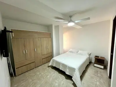 a bedroom with a bed and a large wooden cabinet at Moderno apartamento privado con parqueadero in Barranquilla