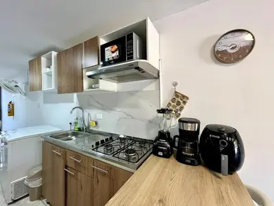 a small kitchen with a stove and a microwave at Moderno apartamento privado con parqueadero in Barranquilla