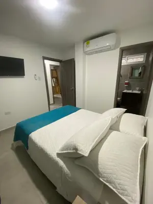 a bedroom with a bed with white sheets and pillows at Palmar in Playa Dormida