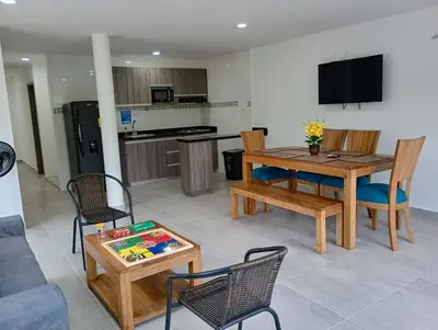 a living room with a table and chairs and a kitchen at Palmar in Playa Dormida