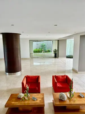 a lobby with red chairs and tables in a building at Apartamento Cartagena in Cartagena de Indias
