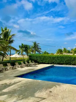 a swimming pool with lounge chairs and palm trees at Apartamento Cartagena in Cartagena de Indias