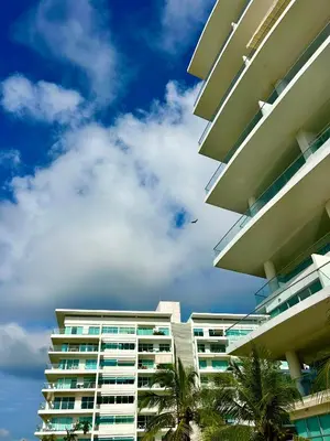 a tall building with palm trees in front of it at Apartamento Cartagena in Cartagena de Indias