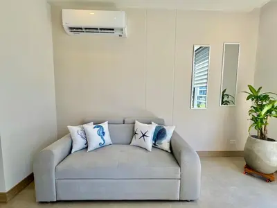a living room with a gray couch with pillows at Spectacular view of the Caribbean Sea in Cartagena de Indias