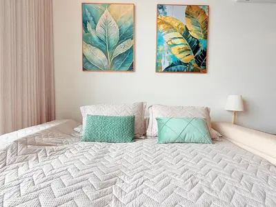 a bedroom with a bed with two paintings on the wall at Premium Apartment - Beachfront - Luxury condo in Cartagena de Indias