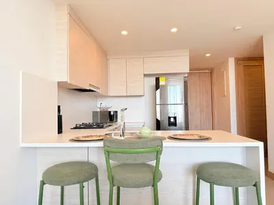 a kitchen with two green chairs and a counter at Premium Apartment - Beachfront - Luxury condo in Cartagena de Indias