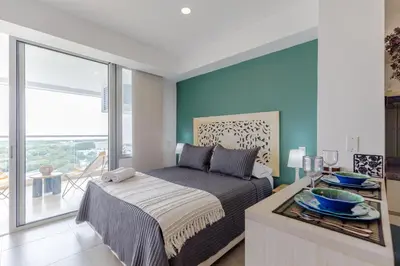 a bedroom with a bed and a large window at Encantador y moderno estudio con piscina a pasos del aeropuerto in Cartagena de Indias