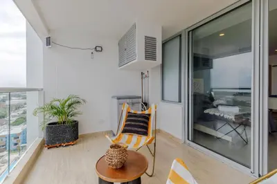 a living room with a chair and a table at Encantador y moderno estudio con piscina a pasos del aeropuerto in Cartagena de Indias