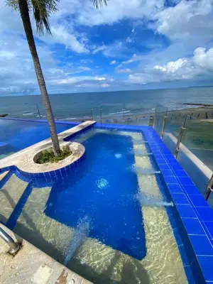 a swimming pool with a palm tree on the beach at Sky Ocean View in Cartagena de Indias