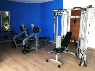 a gym with two tread machines and a blue wall at Sky Ocean View in Cartagena de Indias