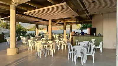 a restaurant with white tables and white chairs at Santa Marina Apartments and Beach Club by Xarm Apartments in Santa Marta