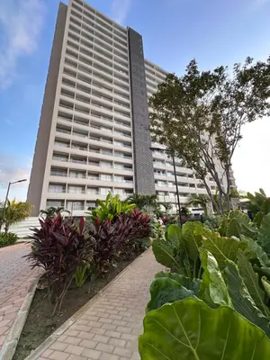 a large white building with plants in front of it at Santa Marina Apartments and Beach Club by Xarm Apartments in Santa Marta