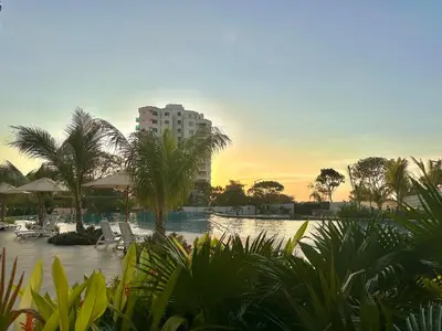 a resort with a pool with palm trees and a building at Santa Marina Apartments and Beach Club by Xarm Apartments in Santa Marta