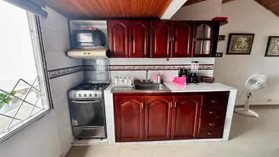 a kitchen with red wooden cabinets and a stove at Apartamento familiar, frente al mar, Bocagrande in Cartagena de Indias