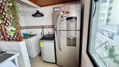 a kitchen with a refrigerator and a trash can at Apartamento familiar, frente al mar, Bocagrande in Cartagena de Indias