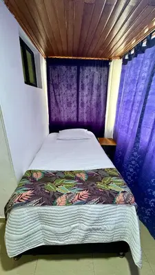 a bed in a room with purple curtains at Apartamento familiar, frente al mar, Bocagrande in Cartagena de Indias
