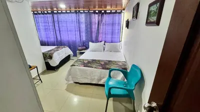 a small bedroom with a bed and a blue chair at Apartamento familiar, frente al mar, Bocagrande in Cartagena de Indias