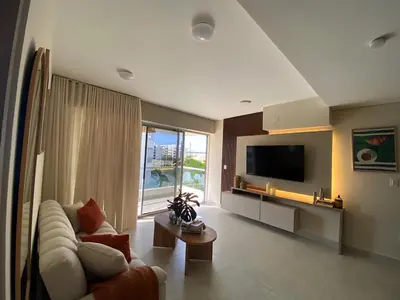 a living room with a couch and a tv at Pool , Private Beach Modern and Serene Apartment in Serena del Mar