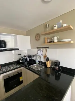 a kitchen with a black counter top and a sink at Pool , Private Beach Modern and Serene Apartment in Serena del Mar