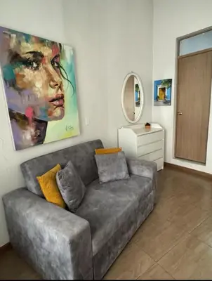 a living room with a couch and a painting on the wall at Exclusive Studio Apartment in the Old City Cartagena in Cartagena de Indias