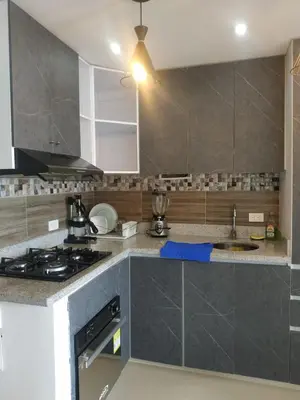 a kitchen with gray cabinets and a stove top oven at Cartagenafantastica in Cartagena de Indias