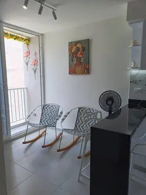 a kitchen with two chairs and a table and a painting at Apartamento en Cartagena amoblado con vista al mar in Cartagena de Indias