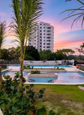 a large swimming pool with a tall building in the background at Santa Marina Santa Marta - By INMOBILIARIA VS in Santa Marta