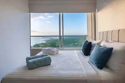 a bedroom with a large bed with blue pillows at Santa Marina Santa Marta - By INMOBILIARIA VS in Santa Marta