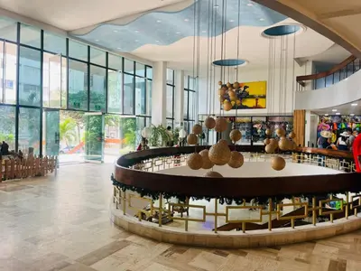 a lobby with a table and chairs and windows at Vacaciones en el Caribe - Laguito Cartagena al lado de bocagrande in Cartagena de Indias