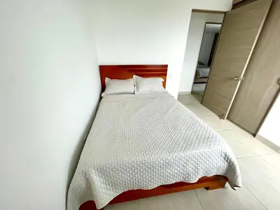 a bedroom with a bed with a white comforter at Exclusividad en el corazón de Barranquilla in Barranquilla