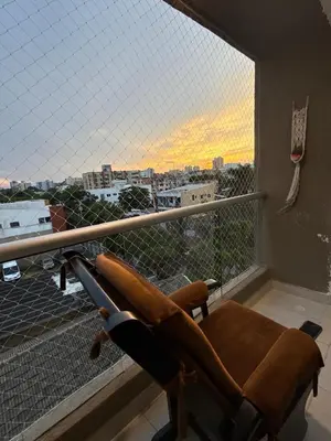 a chair on a balcony with a view of a city at Exclusividad en el corazón de Barranquilla in Barranquilla