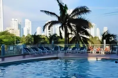 a swimming pool with chairs and a city skyline at Cómodo APTO En El Laguito las 3 Carabelas in Cartagena de Indias