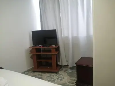 a bedroom with a television on a stand with a bed at Cómodo APTO En El Laguito las 3 Carabelas in Cartagena de Indias
