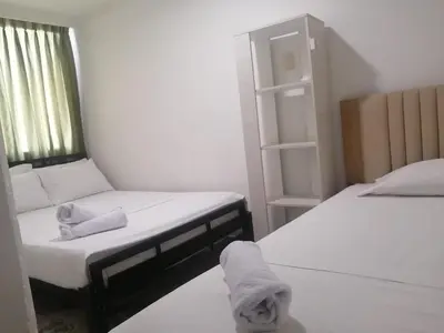 a bedroom with two beds and a book shelf at Cómodo APTO En El Laguito las 3 Carabelas in Cartagena de Indias