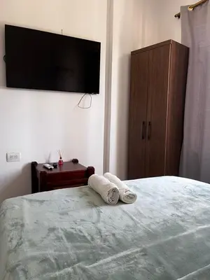 a bedroom with a bed with a television on the wall at Hotel Casa Colonial Moñitos in Moñitos