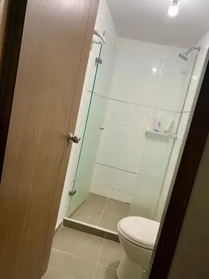 a bathroom with a toilet and a glass shower at Apartamento en villa campestre Barranquilla in Barranquilla