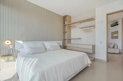 a white bedroom with a large white bed and shelves at Luxury a 100 Mts del Mar en Edificio SeaWay in Cartagena de Indias