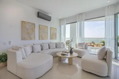 a living room with white furniture and a large window at Luxury a 100 Mts del Mar en Edificio SeaWay in Cartagena de Indias