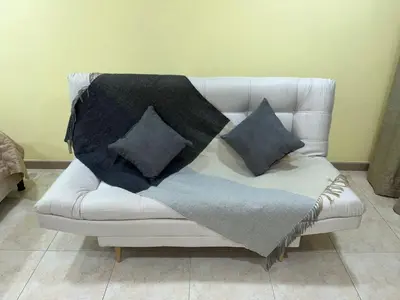 a white couch with two pillows on it at Ebratt Inn in Cartagena de Indias