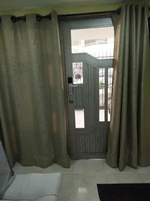 a glass door with curtains in a living room at Ebratt Inn in Cartagena de Indias
